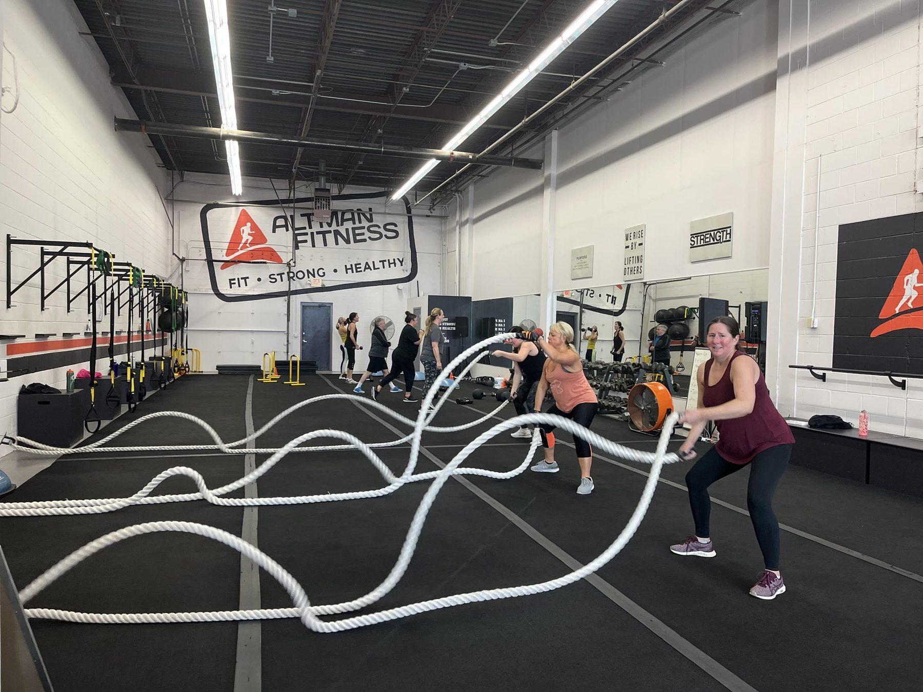 Members working battle ropes during a coached class at Altman Fitness in Edina